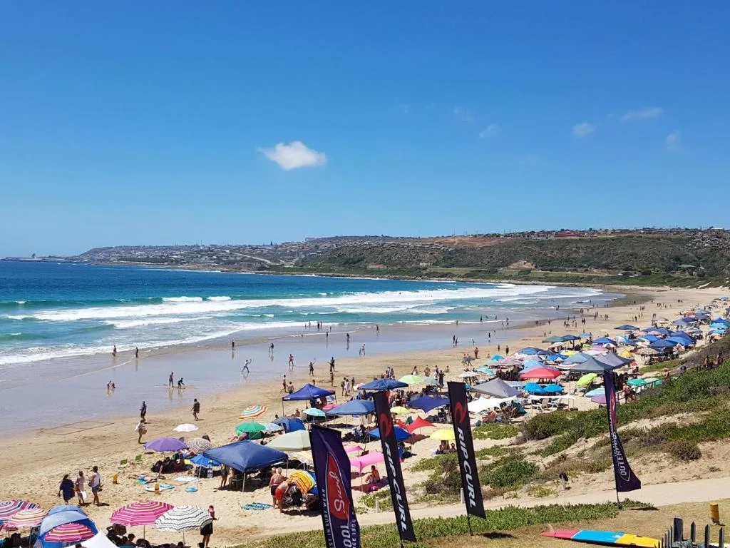Scenic beach cove with turquoise waves and colorful umbrellas lining golden sand