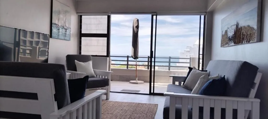 Modern lounge with ocean views through glass doors and sliding windows