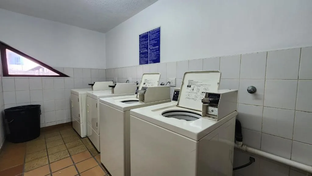 Shared laundry room with multiple washing machines and dryers