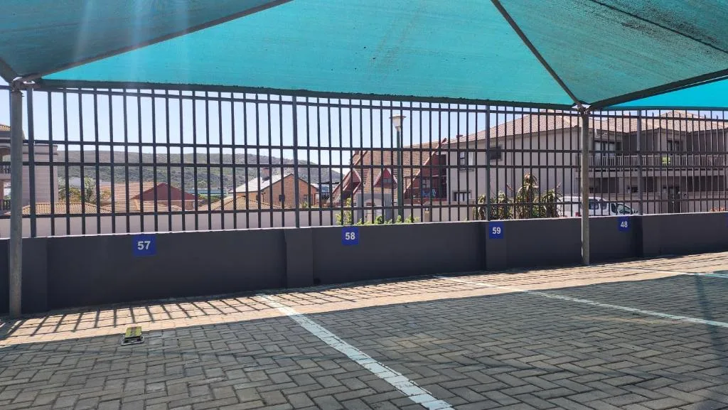Gated entrance and driveway with numbered units and shade cloth covering