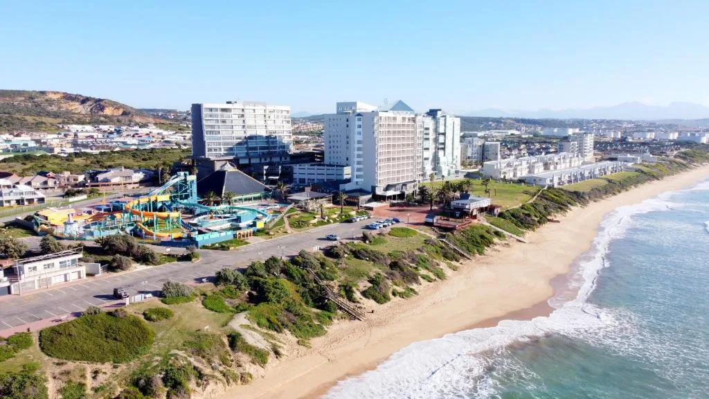 Aerial view of beachfront property with sandy beach and ocean waves