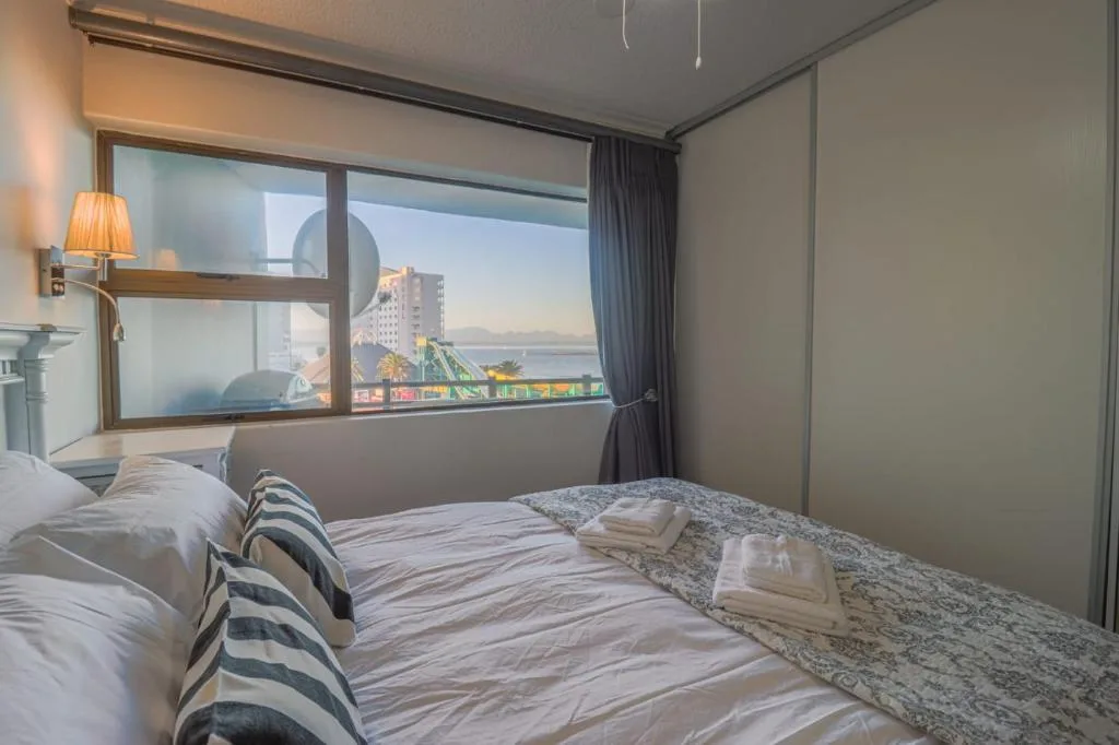 Bedroom with double bed, ocean and lagoon view through large windows