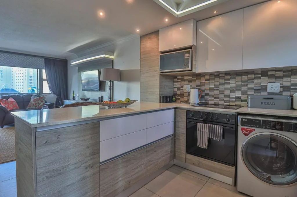 Modern kitchen with island counter, stainless steel appliances, and tiled backsplash
