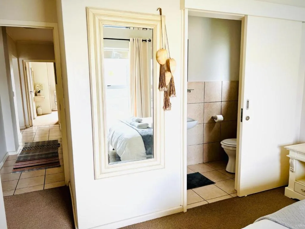 Hallway with bedroom and bathroom doorways visible, decorative hanging ornaments