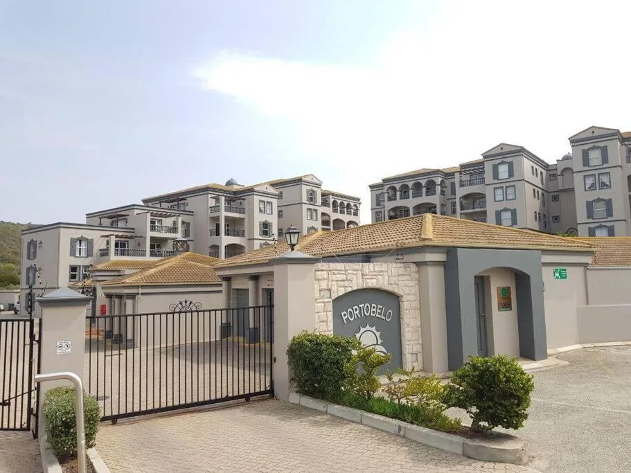 Gated entrance to Portobelo apartment complex with multi-story buildings