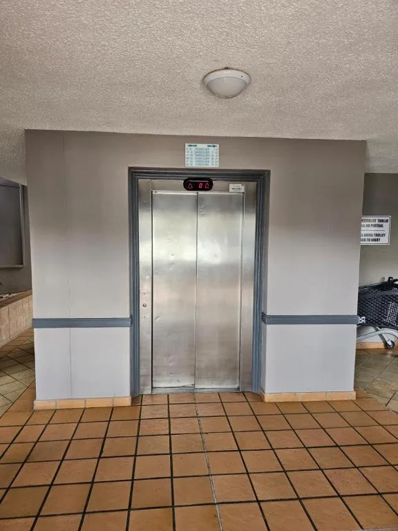 Stainless steel elevator doors in modern apartment building hallway