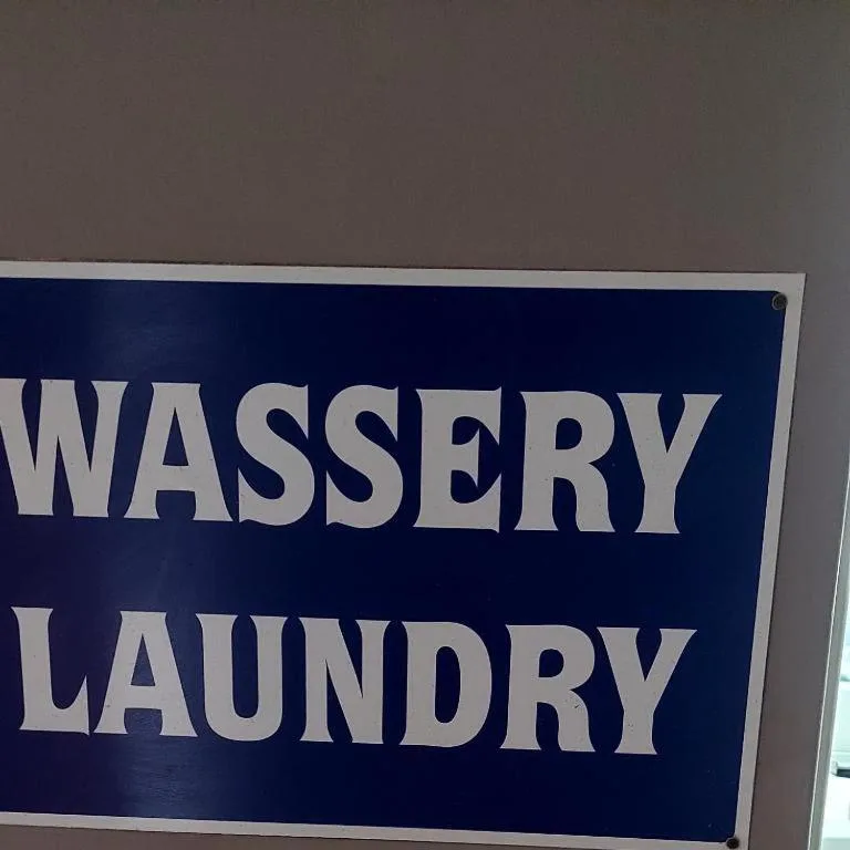 Blue sign indicating wasserij and laundry facilities available at property