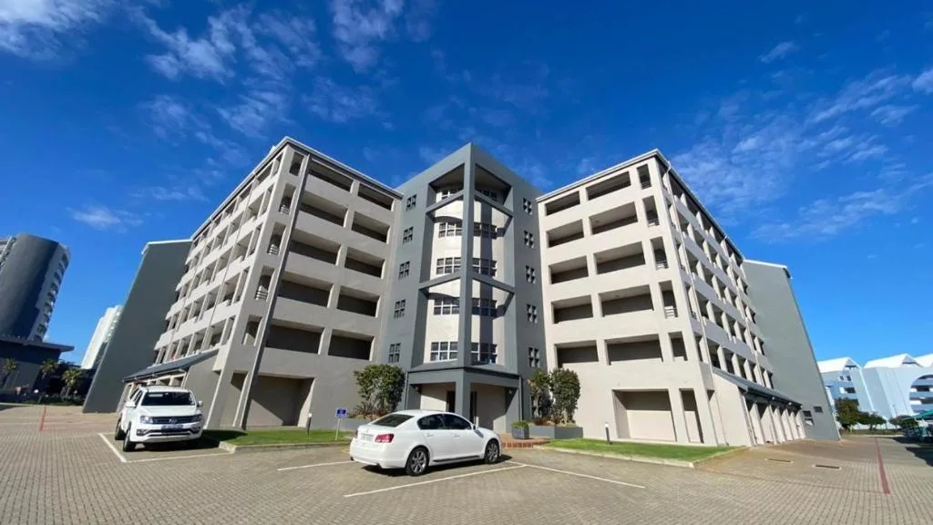 Modern multi-story apartment building with balconies under blue sky