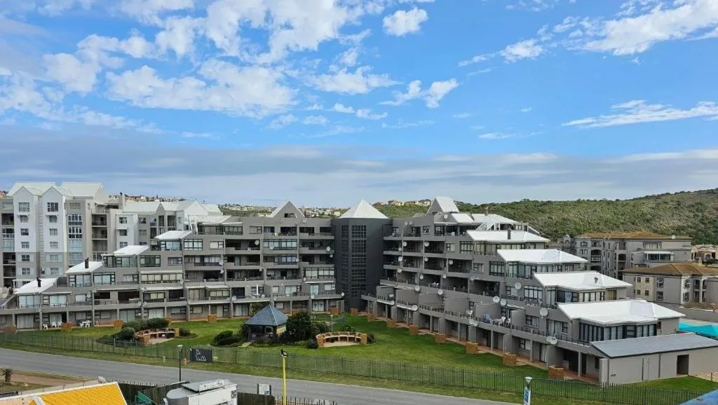 Modern multi-story apartment complex with white and gray facades on hillside