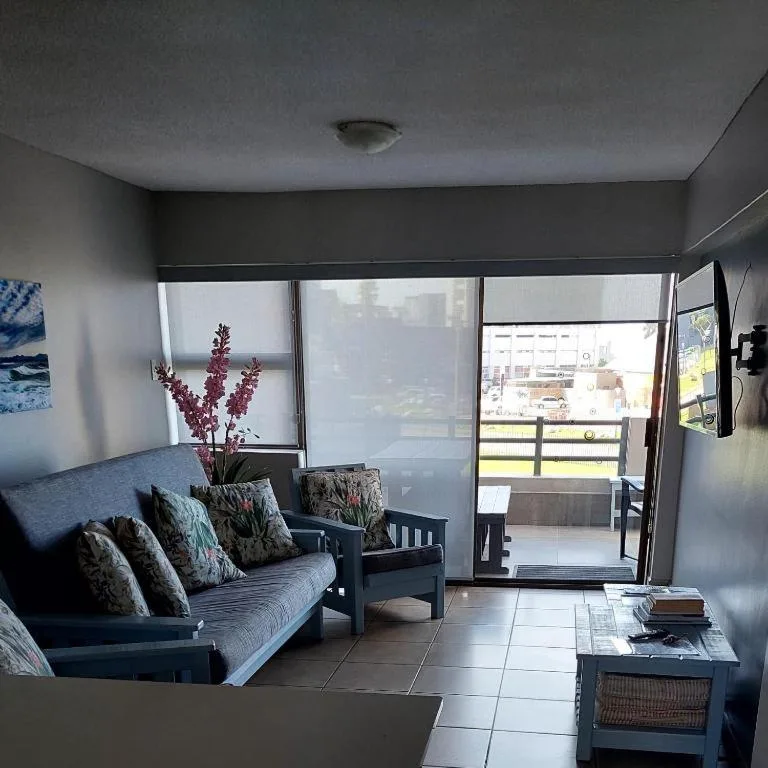 Modern lounge with blue sofa, accent chairs, and large windows overlooking town