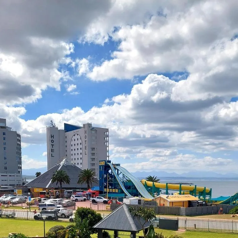 Coastal town panorama with mountains, ocean, and amusement park visible
