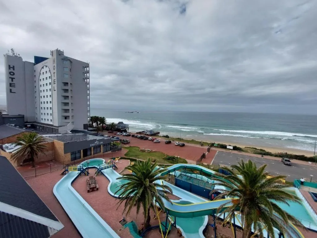 Beachfront property overlooking ocean waves and sandy Mossel Bay coastline