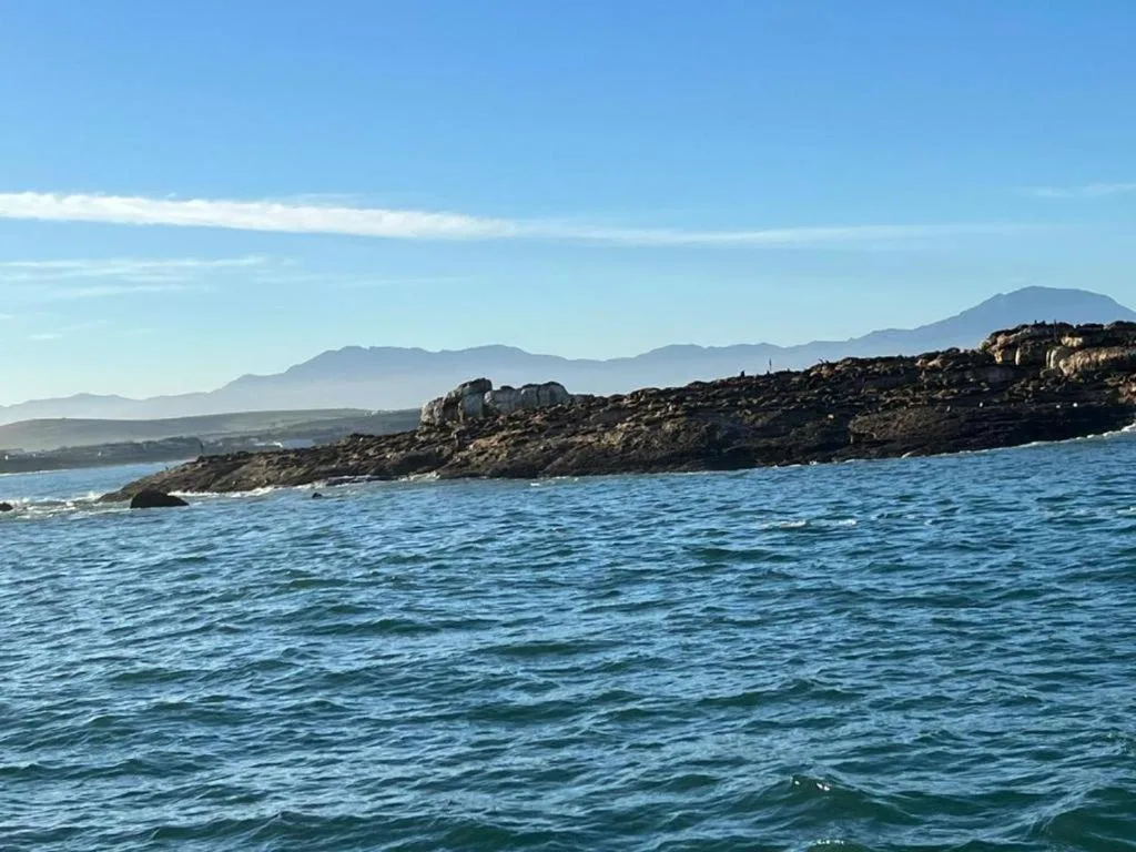 Scenic coastal view with mountains, rocky coastline, and blue ocean water