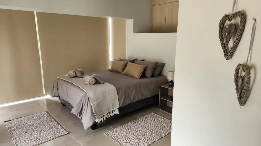 Modern bedroom with king bed, neutral bedding, decorative wall art