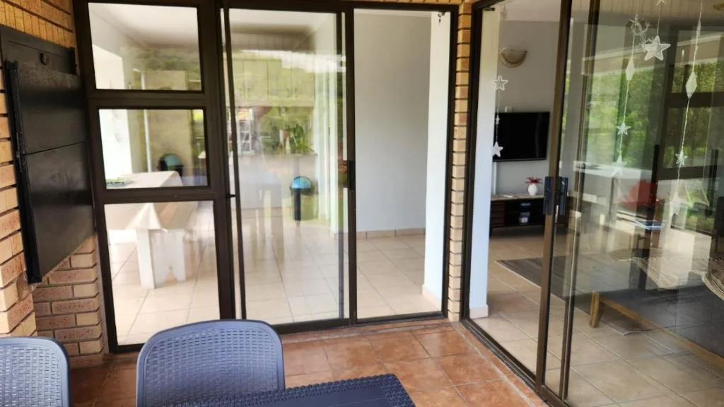 Covered patio with glass sliding doors opening to lounge area