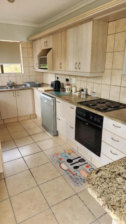 Light wood cabinetry kitchen with black electric stove and dishwasher