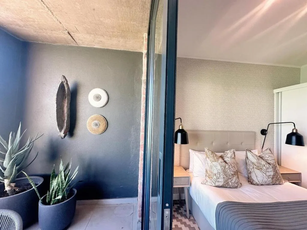 Modern bedroom with neutral upholstered headboard and decorative wall art