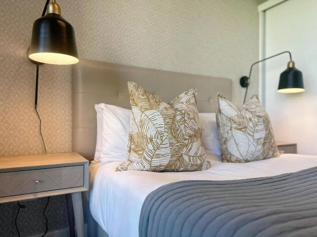 Modern bedroom with patterned cushions, pendant lights, and contemporary decor