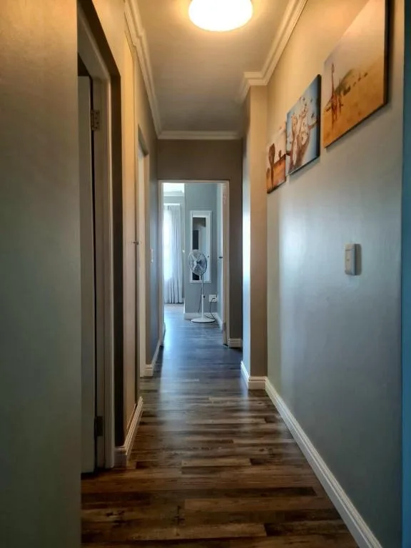 Long hallway with wooden flooring and wall art decor