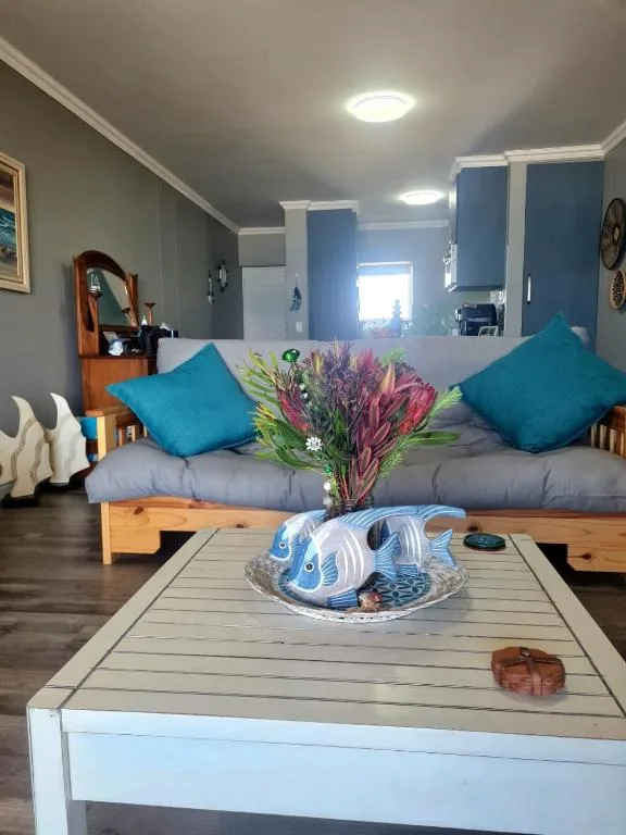 Bright lounge with turquoise cushions, wooden sofa, and decorative coffee table