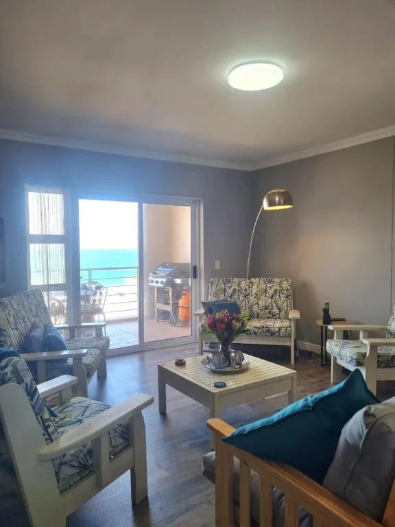 Bright lounge with ocean view through glass doors and coastal patio access