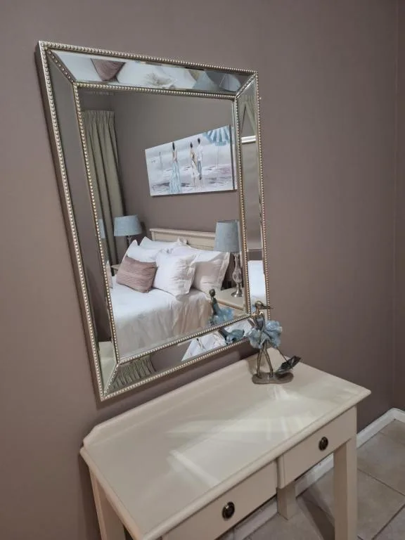 Ornate framed mirror above white vanity table with decorative accents