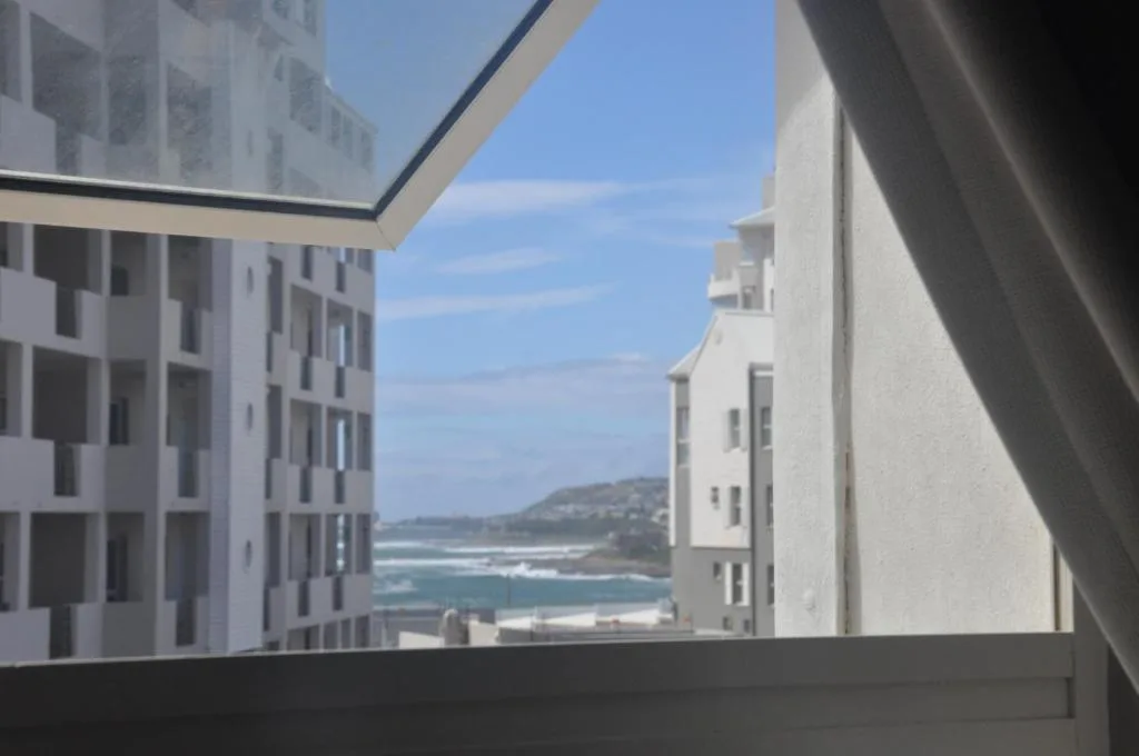Ocean and coastal landscape vista framed between modern white apartment buildings
