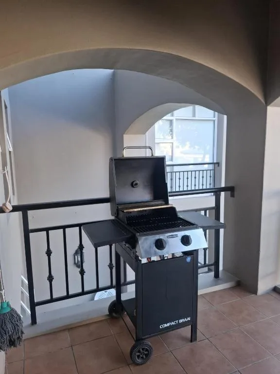 Portable gas braai grill on covered outdoor patio with ocean view