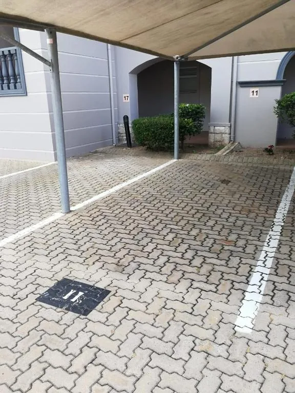 Covered patio area with herringbone paving and parking space number 11