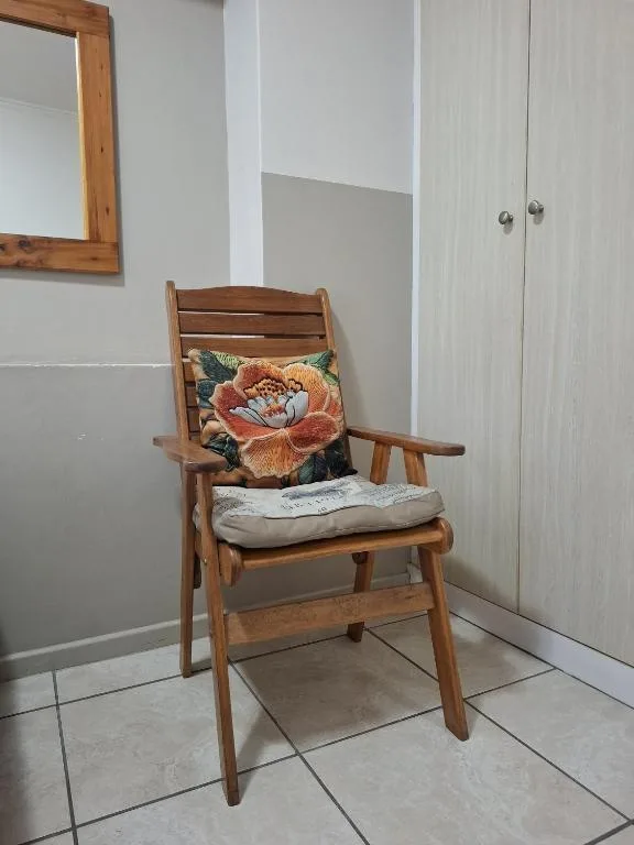 Wooden chair with floral cushion in bright interior room