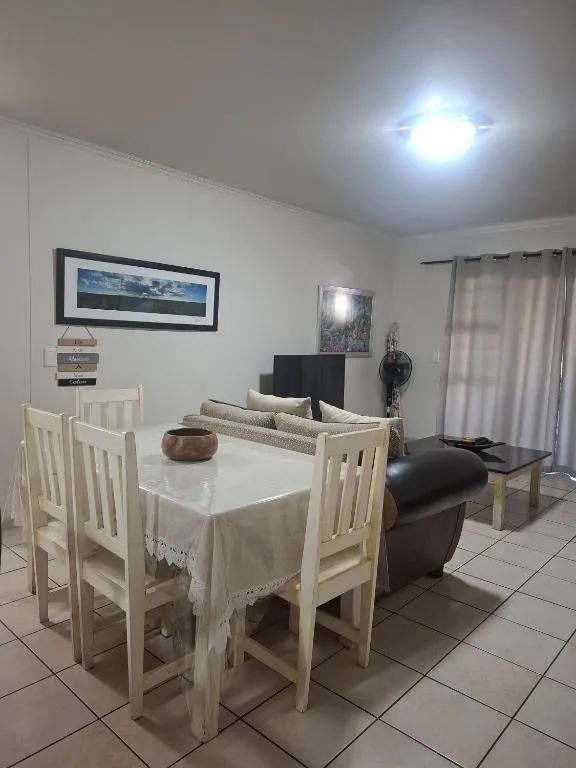 Light wood dining table with four chairs in open-plan living space