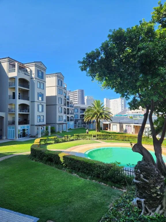 Modern apartment building with manicured gardens and small pool area