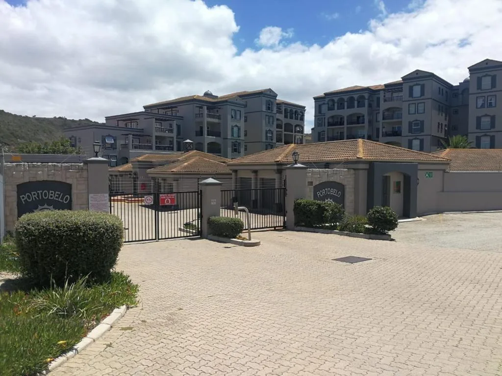Gated entrance to Portobelo apartment complex with landscaped gardens
