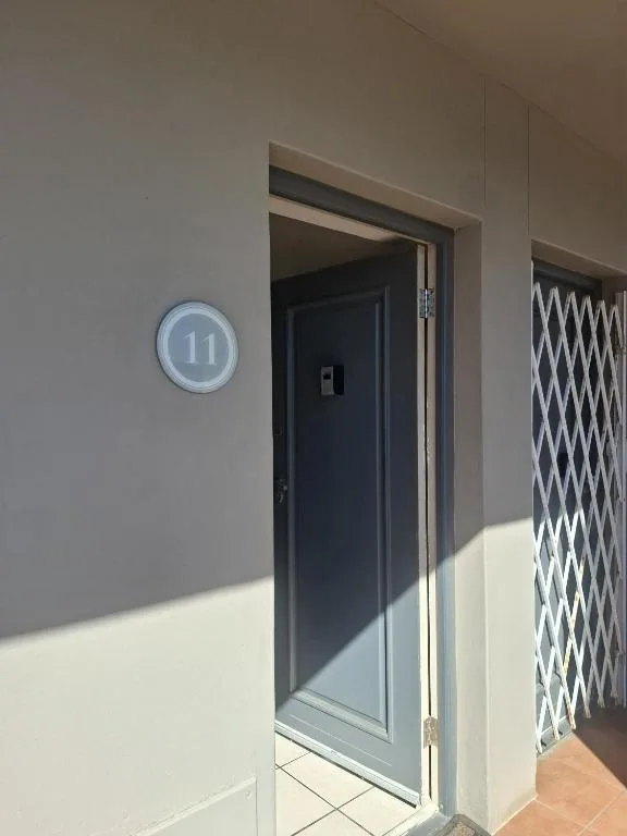 Modern apartment entrance with illuminated number eleven sign on door