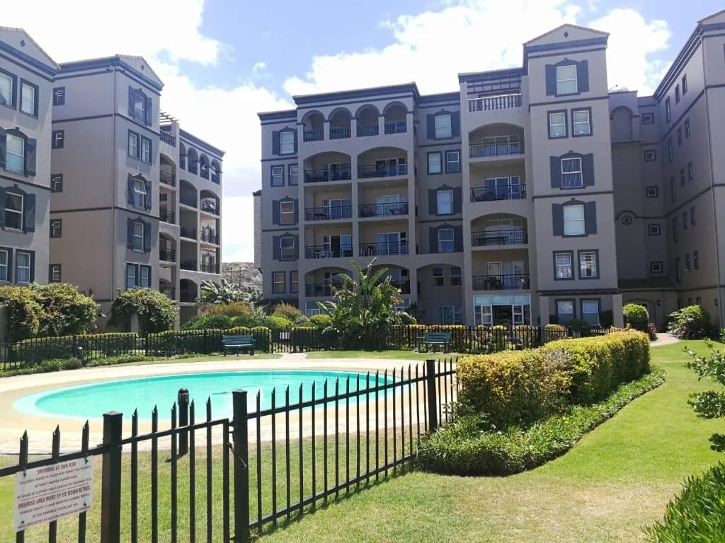 Modern apartment complex with manicured gardens and shared pool area