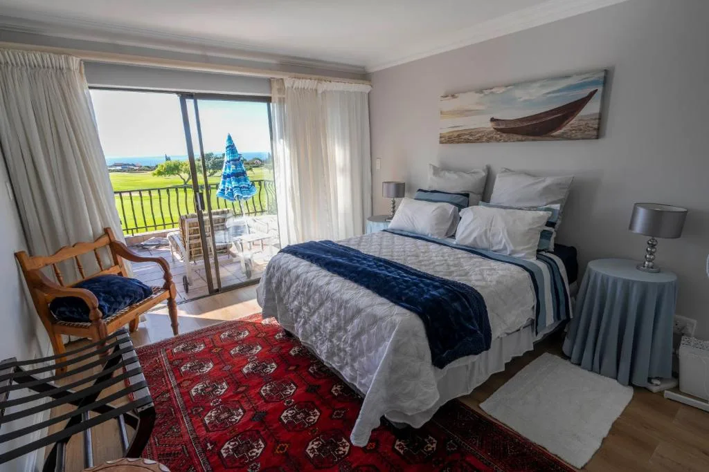 Bright bedroom with king bed, golf course views through glass doors