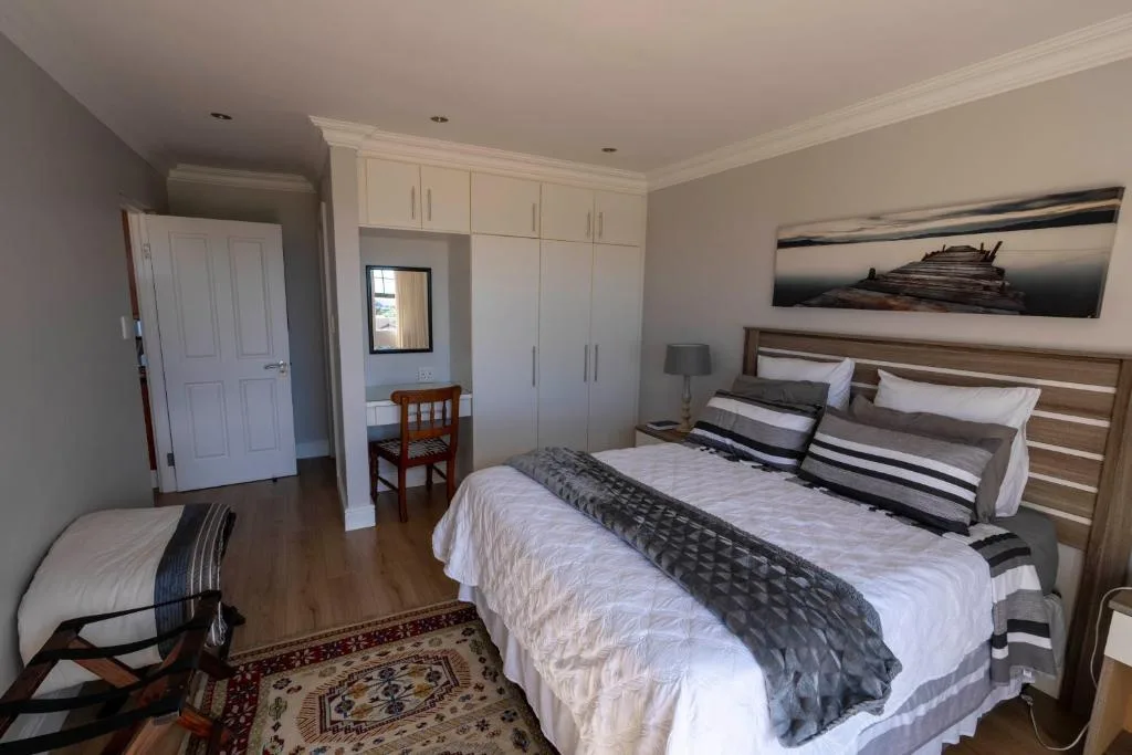 Spacious bedroom with queen bed, built-in wardrobes, and ensuite bathroom access
