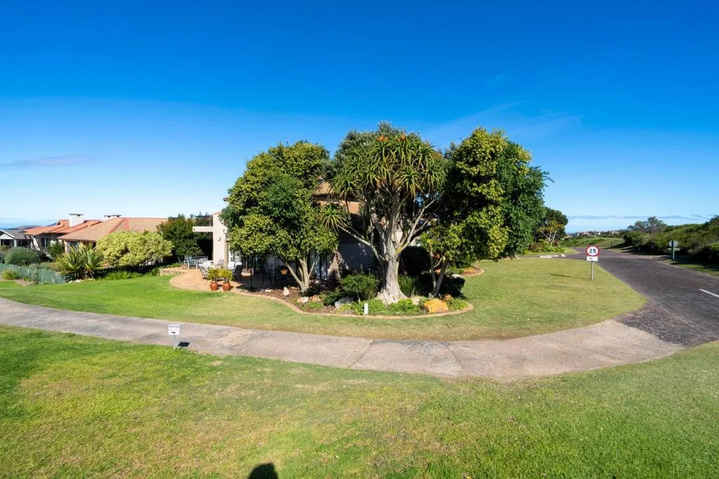 Modern apartment building nestled under mature trees in landscaped Garden Route grounds