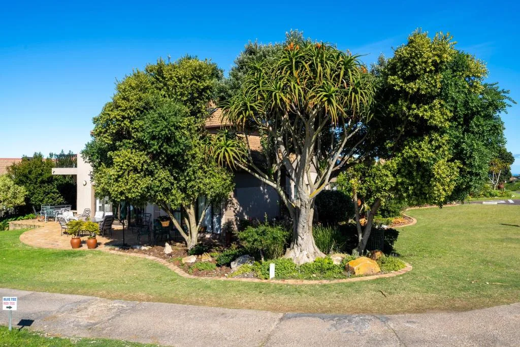 Modern apartment building surrounded by lush gardens and mature trees