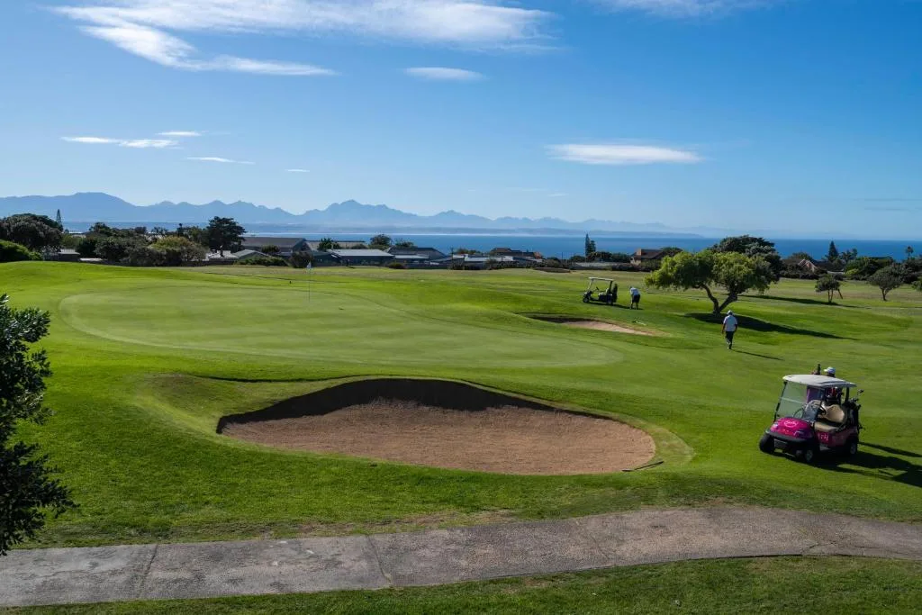 Scenic golf course with mountains and ocean horizon in distance
