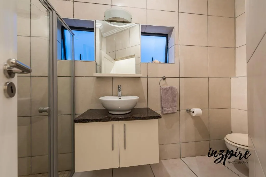 Modern bathroom with vessel sink, mirror cabinet, and shower enclosure