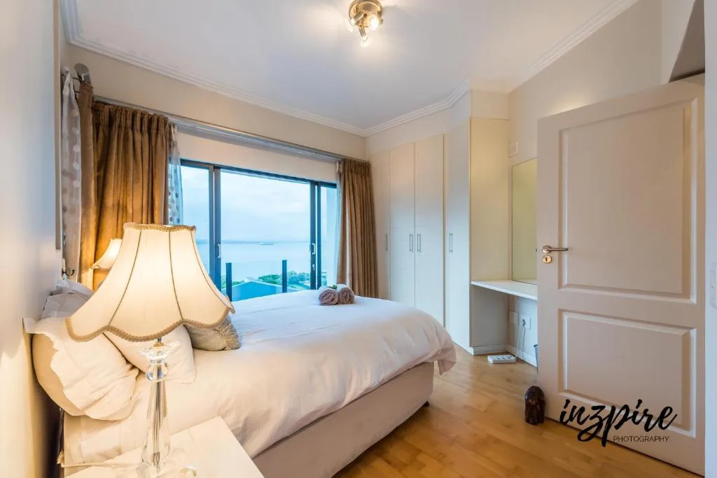 Spacious bedroom with ocean view through sliding doors and modern furnishings