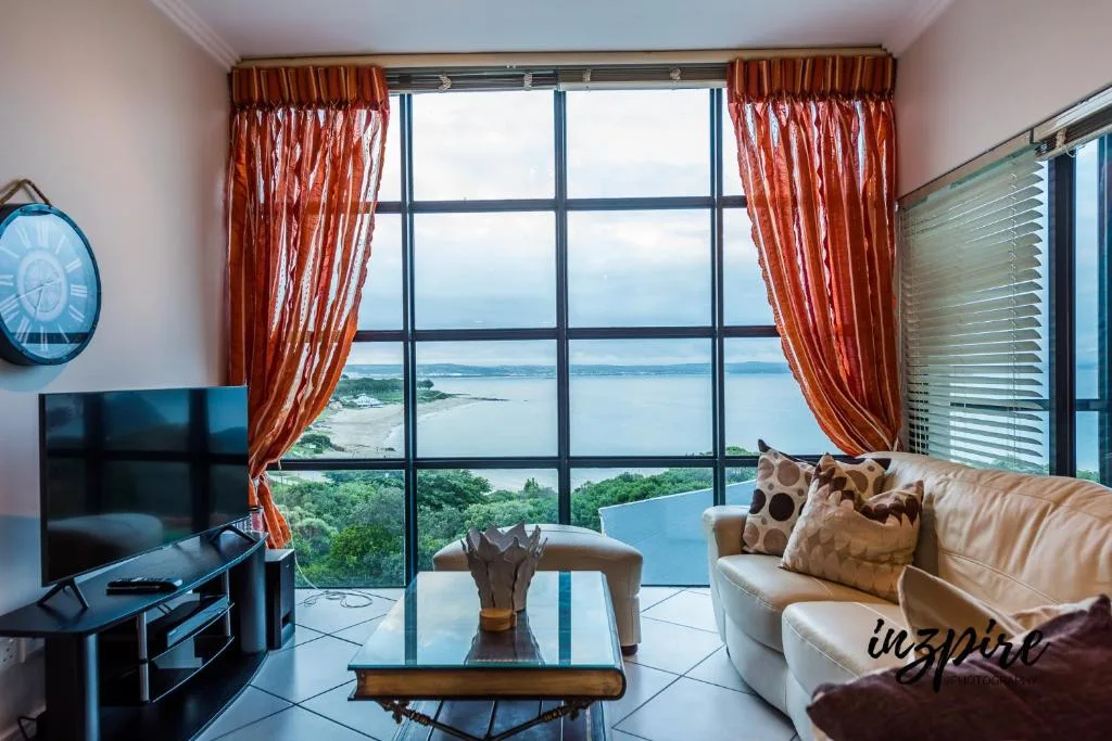 Lagoon view through large windows with red curtains and coastal landscape