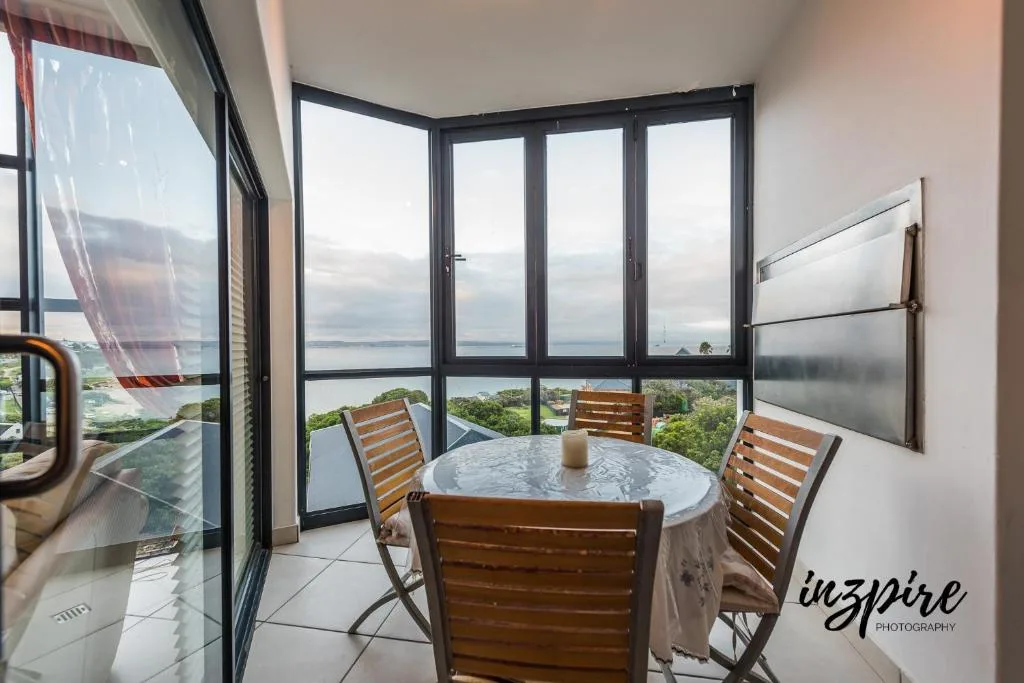 Dining area with expansive lagoon and coastal landscape views through large windows