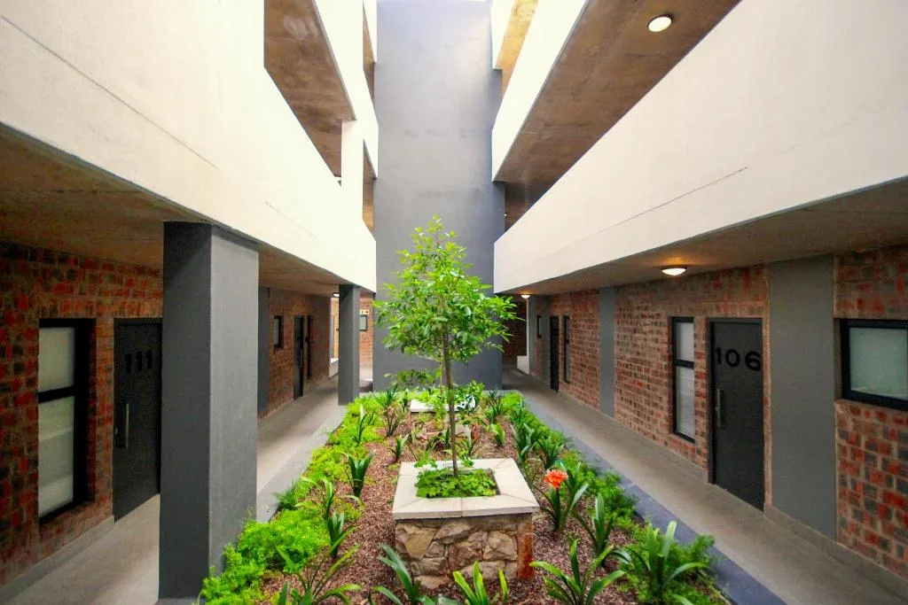 Modern apartment complex courtyard with central garden and brick facade