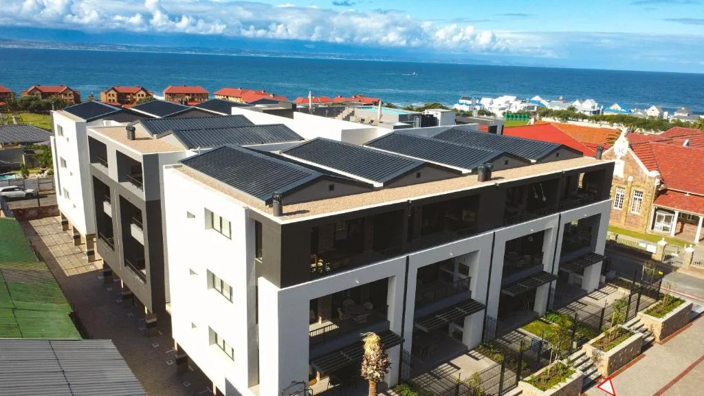Modern white and black apartment building with ocean views and solar panels