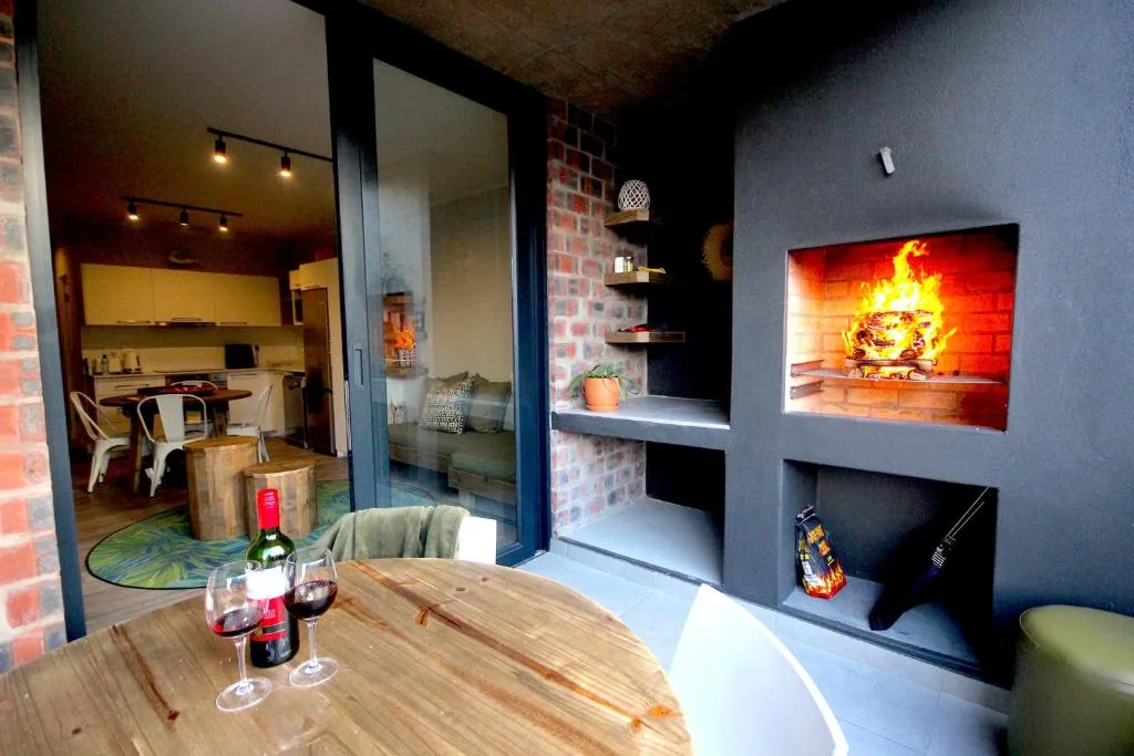 Modern lounge with fireplace, wine glasses, and open-plan kitchen view