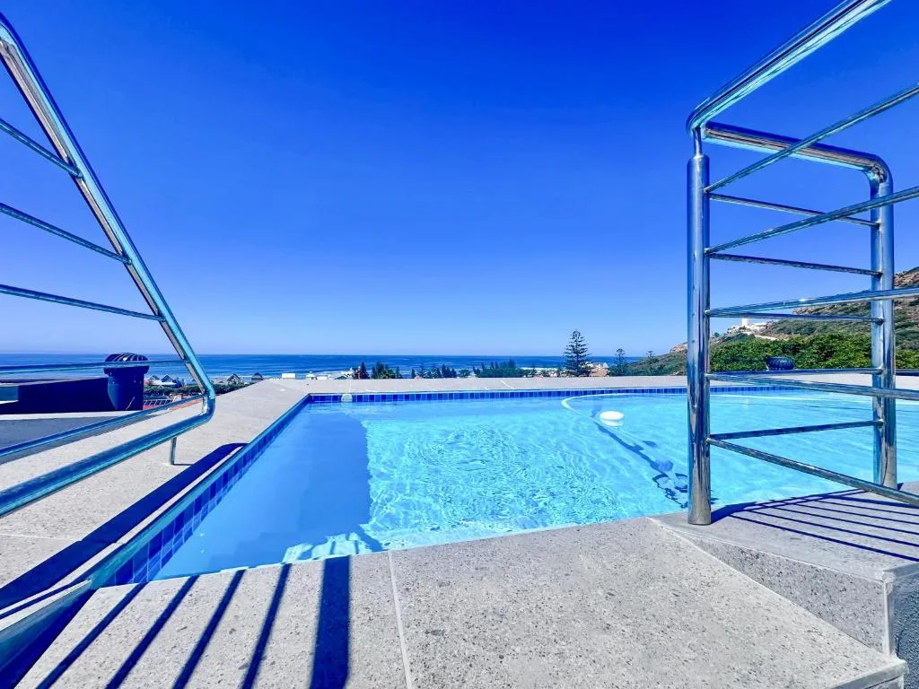 Crystalline swimming pool overlooking the ocean and coastal landscape