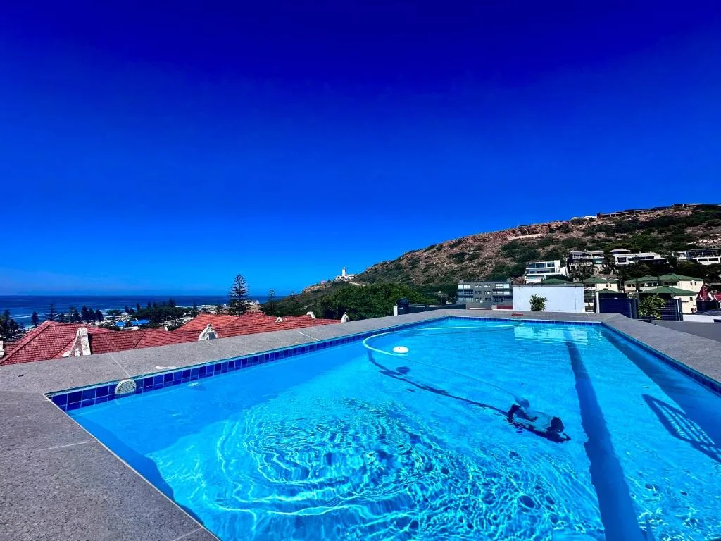 Sparkling blue swimming pool overlooking Mossel Bay coastline and hills
