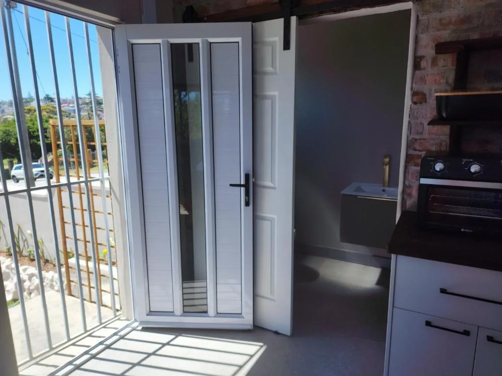 Modern kitchen with built-in oven and deck access overlooking Mossel Bay